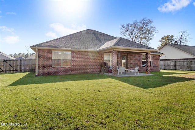 rear view of property with a lawn and a patio