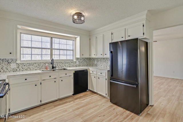 kitchen featuring dishwasher, light wood-type flooring, freestanding refrigerator, and a sink