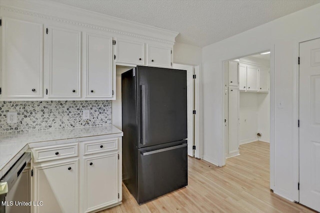 kitchen featuring light countertops, dishwashing machine, freestanding refrigerator, light wood-style floors, and white cabinetry