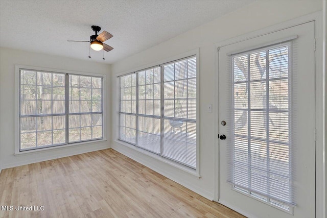 unfurnished sunroom with a ceiling fan