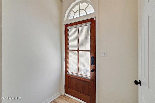 doorway with light wood-type flooring and baseboards