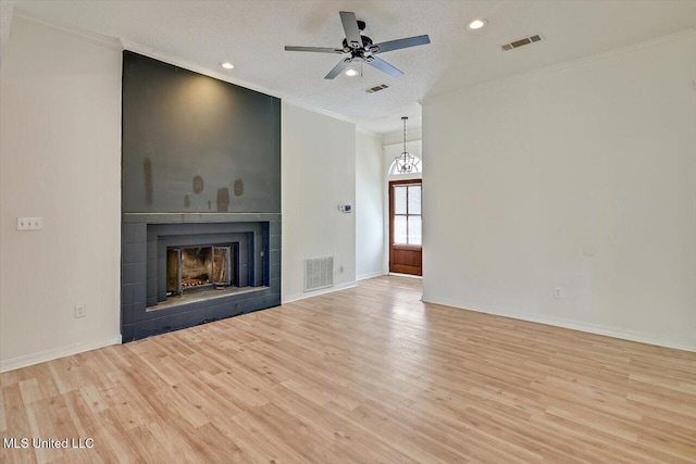 unfurnished living room with crown molding, a fireplace, and visible vents