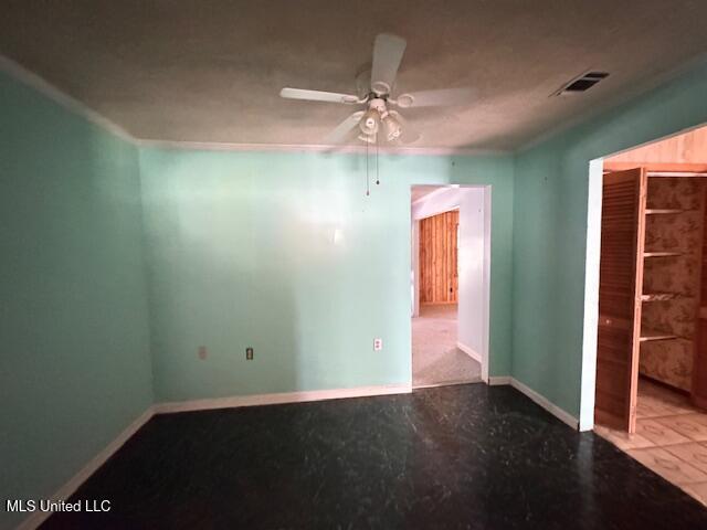 spare room with baseboards, ceiling fan, and visible vents