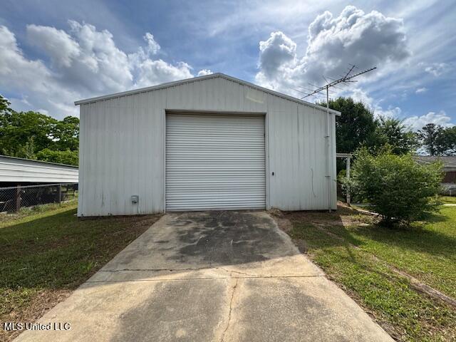 view of outdoor structure with concrete driveway and an outbuilding