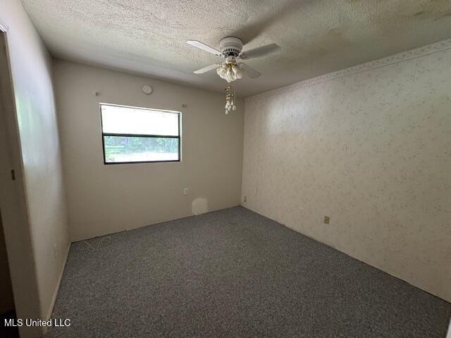 carpeted empty room featuring a textured ceiling and ceiling fan