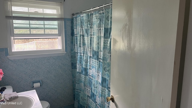 bathroom with toilet and a shower with shower curtain