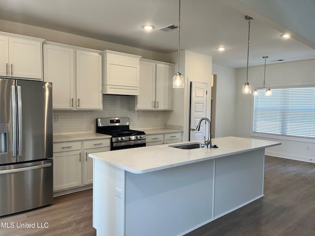 kitchen featuring appliances with stainless steel finishes, a sink, dark wood-style floors, decorative backsplash, and white cabinetry