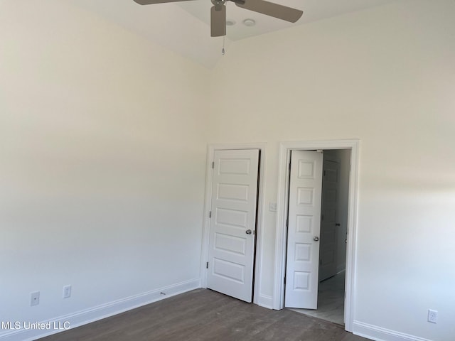 unfurnished bedroom with baseboards, dark wood-style floors, high vaulted ceiling, and ceiling fan