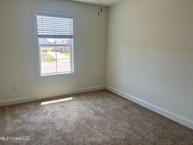 empty room featuring carpet floors and baseboards