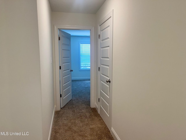 corridor with dark carpet and baseboards