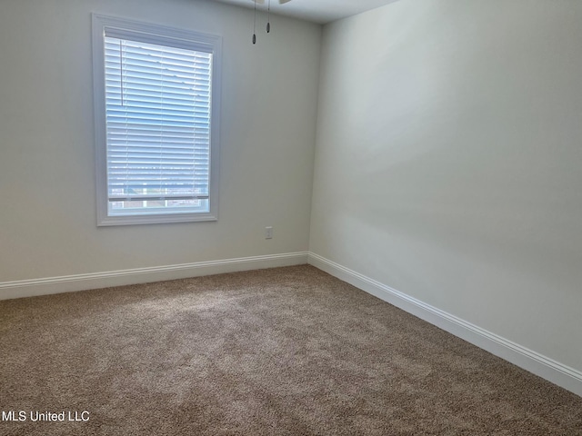 empty room with carpet floors, baseboards, and a ceiling fan
