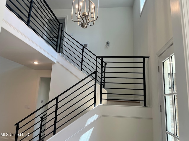 stairs with a chandelier and a high ceiling