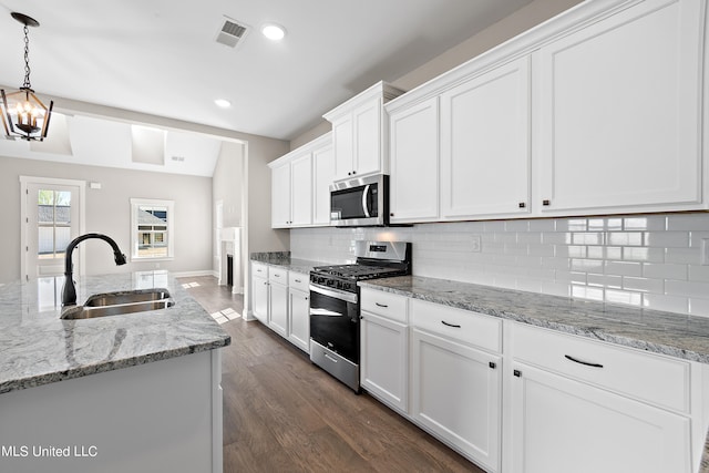 kitchen with sink, white cabinetry, stainless steel appliances, and hanging light fixtures