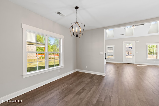 empty room with dark wood-type flooring and ceiling fan with notable chandelier