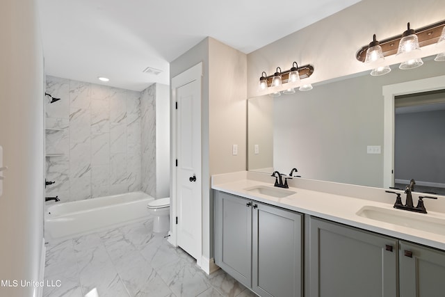 full bathroom featuring vanity, tiled shower / bath combo, and toilet