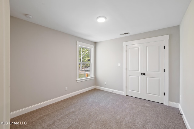 unfurnished bedroom with a closet and carpet floors