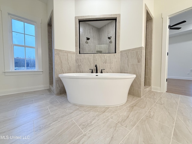 bathroom with separate shower and tub, ceiling fan, and tile walls