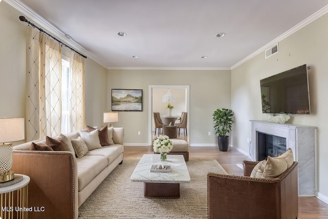 living room featuring crown molding and light hardwood / wood-style flooring