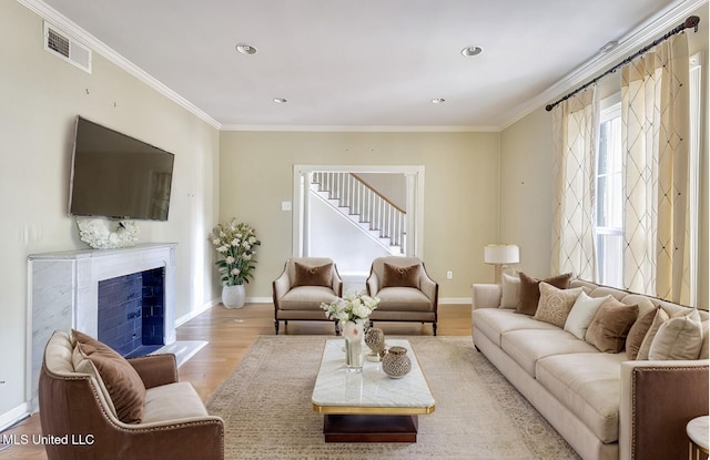 living room with crown molding and light hardwood / wood-style floors