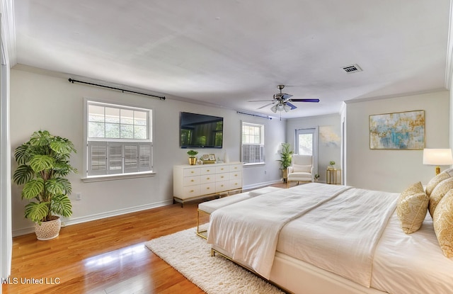 bedroom with crown molding, ceiling fan, light hardwood / wood-style floors, and multiple windows