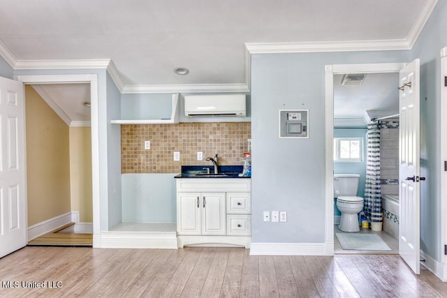 kitchen featuring hardwood / wood-style floors, crown molding, sink, and a wall mounted AC