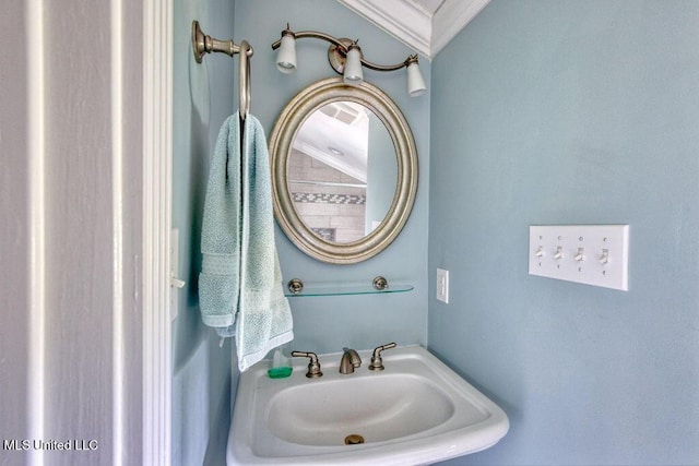 bathroom with crown molding and sink