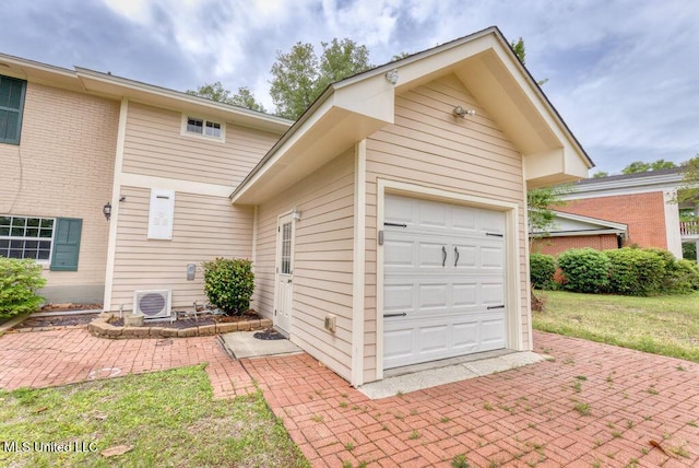 garage with ac unit and a lawn