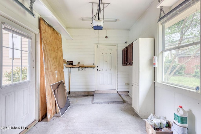 interior space featuring a garage door opener and wooden walls