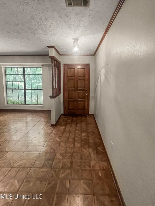 doorway featuring ornamental molding, a notable chandelier, and a textured ceiling