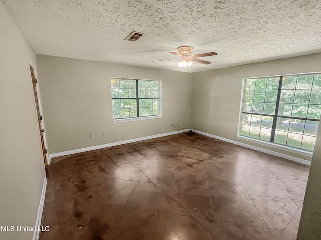 unfurnished room with a textured ceiling, a healthy amount of sunlight, and ceiling fan