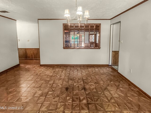 unfurnished dining area featuring parquet flooring, a notable chandelier, a textured ceiling, and wood walls