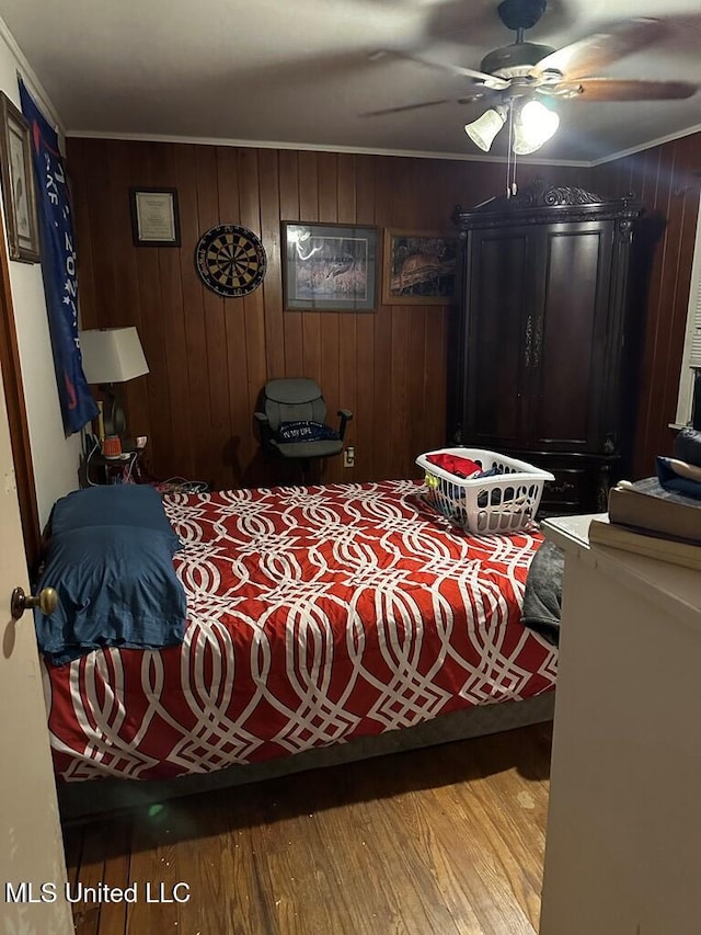 bedroom featuring light hardwood / wood-style flooring, wooden walls, and ceiling fan