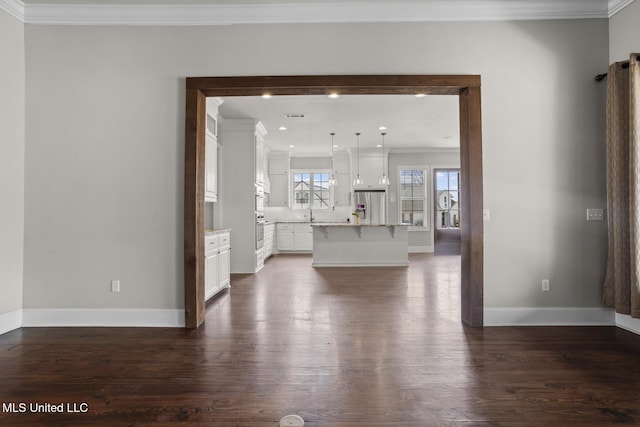 unfurnished living room featuring crown molding, baseboards, dark wood-style flooring, and visible vents