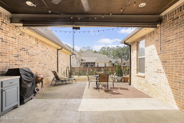 view of patio with outdoor dining space, a grill, and fence