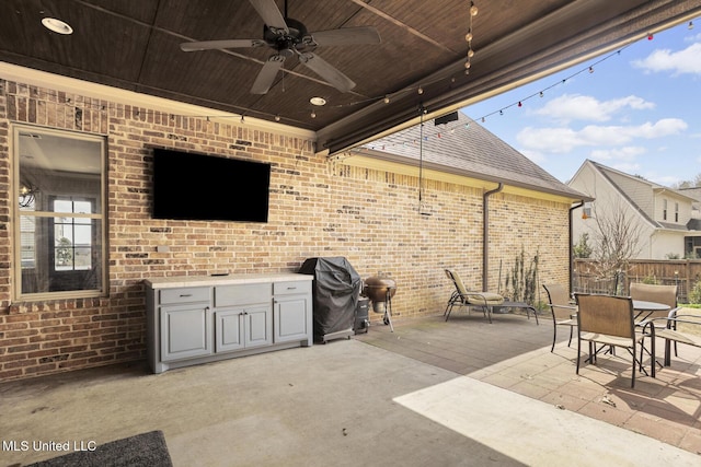 view of patio featuring area for grilling, fence, and ceiling fan