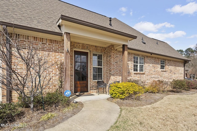 property entrance with brick siding and a shingled roof