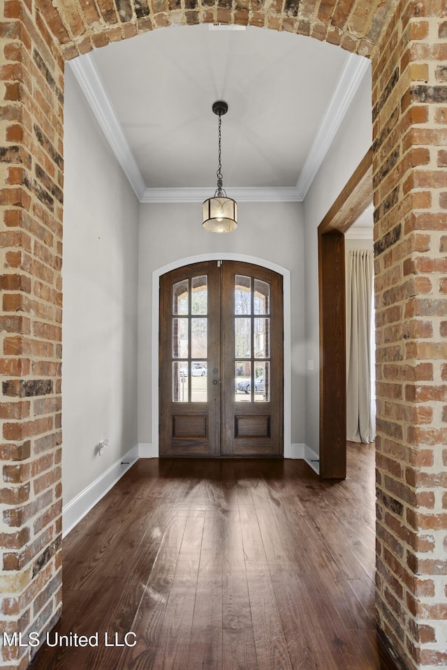 foyer entrance with french doors, baseboards, dark wood-type flooring, and ornamental molding