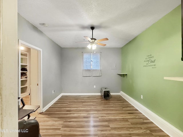 interior space featuring hardwood / wood-style floors, ceiling fan, and a textured ceiling