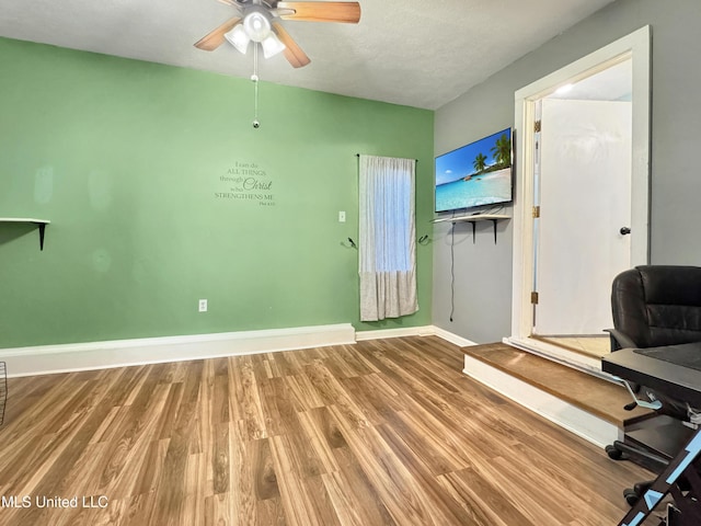 unfurnished office with hardwood / wood-style flooring, ceiling fan, and a textured ceiling