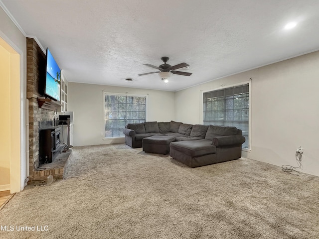 living room featuring carpet flooring, ceiling fan, and a textured ceiling