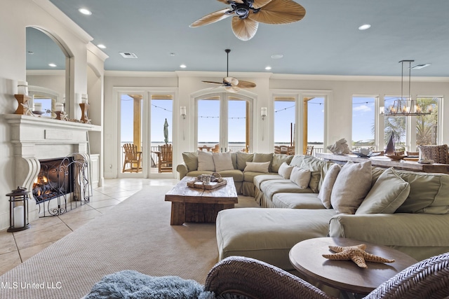 living room featuring ceiling fan, light tile patterned floors, a fireplace with flush hearth, ornamental molding, and recessed lighting
