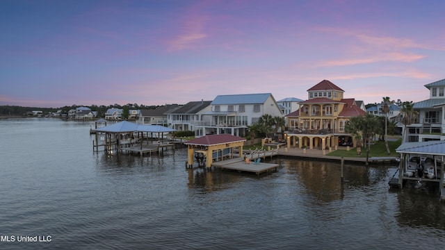 dock area with boat lift, a water view, and a residential view