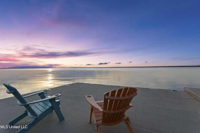 patio terrace at dusk featuring a water view