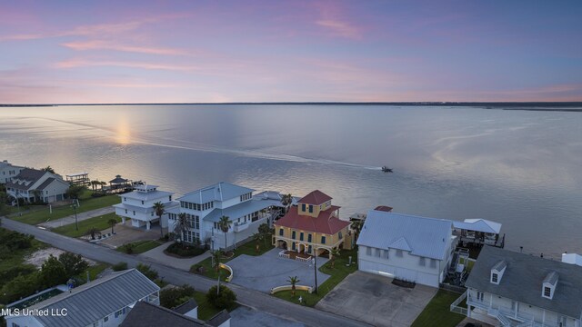 aerial view at dusk of a water view and a residential view