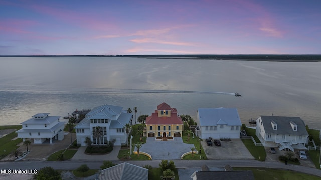 aerial view at dusk of a water view and a residential view