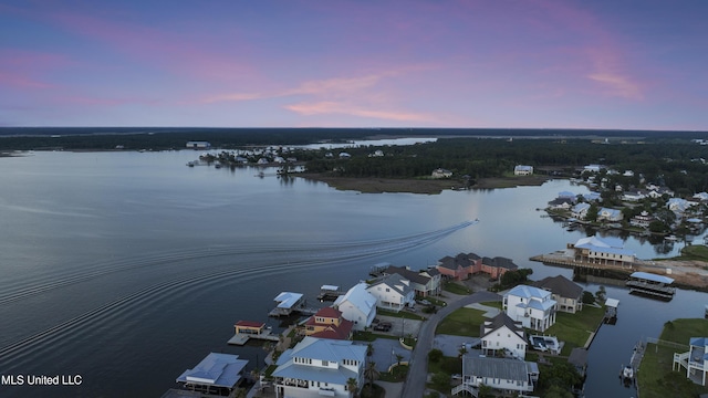 aerial view at dusk of a water view and a residential view