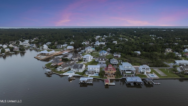 aerial view at dusk of a water view and a residential view