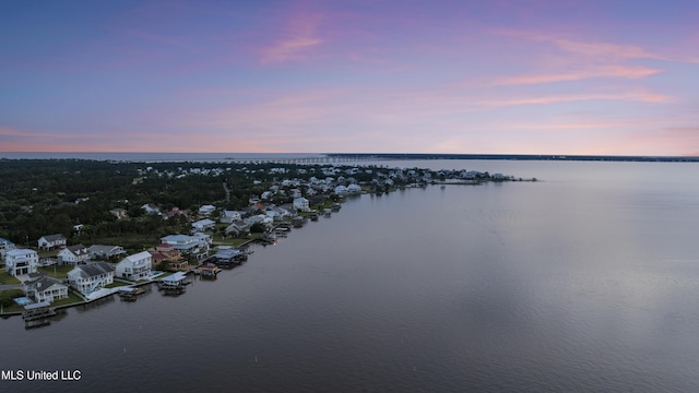 aerial view at dusk of a water view and a residential view