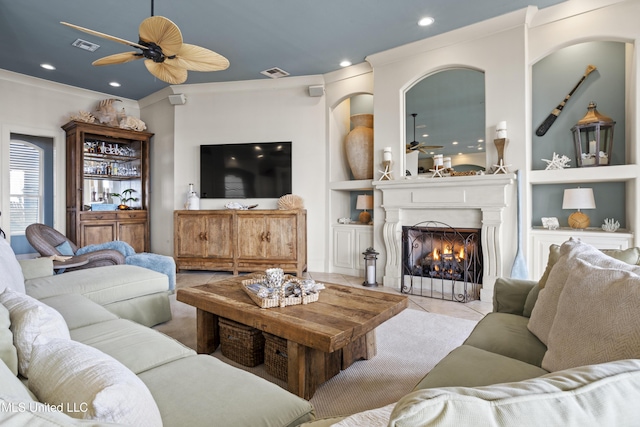 tiled living area with ceiling fan, a fireplace with flush hearth, ornamental molding, built in features, and bar area