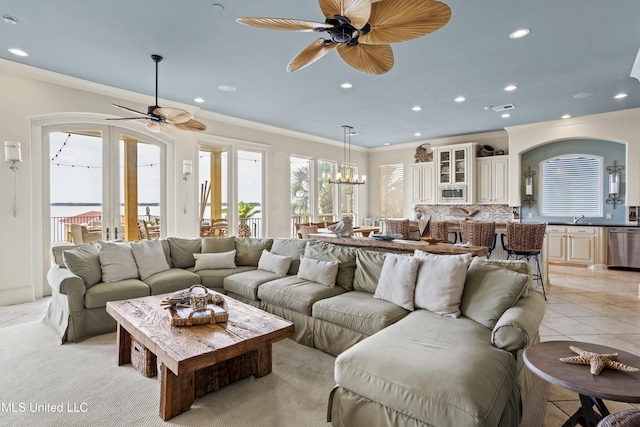living room featuring a ceiling fan, crown molding, recessed lighting, light tile patterned flooring, and a chandelier